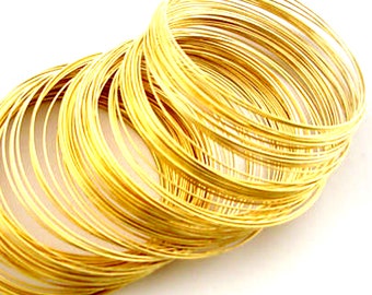 Puede incluir: Una pila de anillos de alambre de color dorado, perfectos para la elaboración de joyas u otros proyectos de bricolaje.