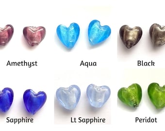 May include: Assortment of heart-shaped glass beads in various colors, including amethyst, aqua, black, sapphire, light sapphire, and peridot.