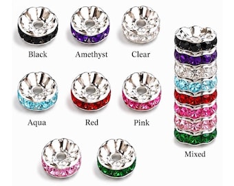 May include: A collection of round metal spacer beads featuring a central hole and a band of embedded crystals in various colors including black, amethyst, clear, aqua, red, pink, rose, and green, with a vertical stack showing all colors.