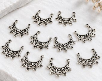 May include: A collection of ten silver-toned metal jewelry connectors, each shaped like a crescent moon with intricate filigree scrollwork patterns and five small circular loops along the bottom edge for attaching additional jewelry components.