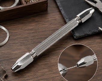 May include: A silver-toned metal pin vise tool featuring a textured, cylindrical handle and two adjustable collet chucks at each end. A circular inset shows the tool holding a thin, twisted silver wire between its two metal chuck ends.