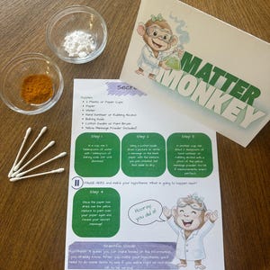 May include: A science activity kit titled Matter Monkey featuring a printed instruction sheet with four steps, a cartoon monkey in a lab coat, two small glass bowls containing white and orange powders, and four white cotton swabs for experiments.