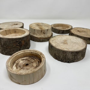 May include: A set of six wooden coasters made from tree bark. The coasters are round and have a natural, rustic look. They are perfect for adding a touch of nature to your home decor.