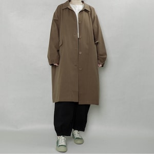 May include: A long brown coat with a button-up front and long sleeves. The coat is made of a lightweight fabric and has a relaxed fit.