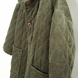 May include: A quilted green corduroy jacket with a button-up front and two patch pockets.
