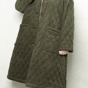 May include: A long, quilted, olive green corduroy coat with a button closure and two large pockets.