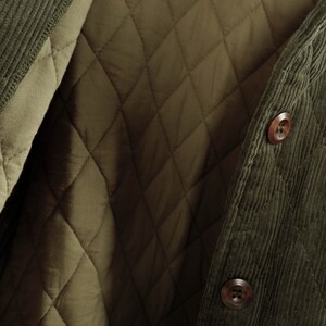 May include: A green corduroy jacket with a quilted lining. The jacket has a button closure and a corduroy collar.