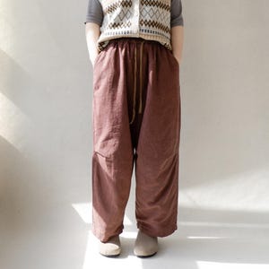 May include: A pair of loose-fitting, brown, linen pants with a drawstring waist.