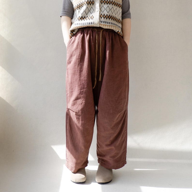 May include: A pair of loose-fitting, brown, linen pants with a drawstring waist.