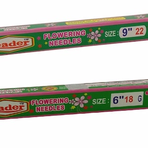 Puede incluir: Dos cajas verdes y rosas de agujas para flores de la marca Leader. La caja superior está etiquetada "Tamaño: 9" 22" y la caja inferior está etiquetada "Tamaño: 6" 18 G".