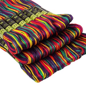 May include: A close-up of a stack of eight spools of embroidery floss. The floss is multi-coloured, with stripes of red, yellow, green, and purple. Each spool is labelled with the text "Art. 4615 100% Cotton 8m 375".