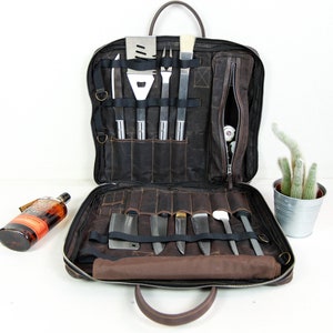May include: A brown leather carrying case with a zippered pocket and multiple slots for holding grilling tools and knives. The case is open and the tools are visible.