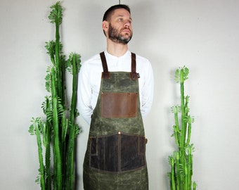 May include: A green canvas apron with brown leather accents and a large pocket. The apron has adjustable straps and a tool loop.