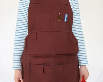 Delantal de carpintería de lona color marrón castaño: bolsillo magnético, tirantes ajustables cruzados en la espalda.