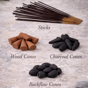 May include: An assortment of incense products, including sticks, wood cones, charcoal cones, and backflow cones. The image displays the products on a textured surface, with text labels identifying each type of incense. The sticks are brown with gold tips.