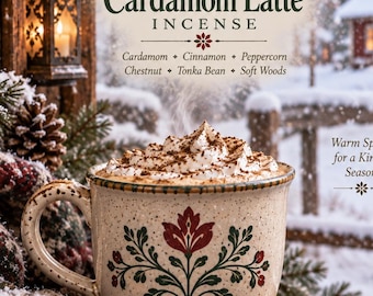 May include: A speckled ceramic mug filled with a latte topped with whipped cream and dark sprinkles. The mug features a red and green floral design. Text reads: Snowfall Cardamom Latte INCENSE, Cardamom, Cinnamon, Peppercorn, Chestnut, Tonka Bean, Soft Woods.
