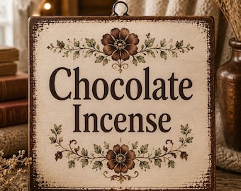 Może przedstawiać: Prostokątny drewniany szyld z postarzaną brązową ramką i kremowym środkiem. Napis "Chocolate Incense" wykonany jest ciemnobrązową czcionką, otoczony brązowymi ilustracjami kwiatów u góry i u dołu z zielonymi liśćmi.