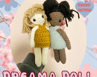 May include: Two crocheted dolls, one with blonde hair and a yellow dress, the other with black hair and a blue dress. The dolls are holding hands and the text "CROCHET PATTERN" is in a pink heart shape above them. The text "DREAMA DOLL" is at the bottom of the image.