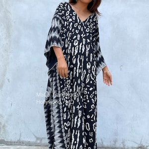 May include: A black and white maxi dress with a leopard print pattern. The dress has a V-neckline and long, flowing sleeves. The dress is made of a soft, comfortable fabric and is perfect for a casual or dressy occasion.