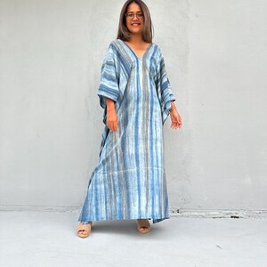 Puede incluir: Un vestido maxi largo de rayas azules y blancas con escote en V y corte holgado.