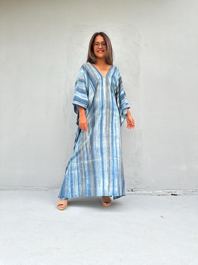 Puede incluir: Un vestido maxi largo de rayas azules y blancas con escote en V y corte holgado.
