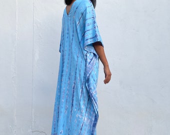 May include: A long, flowing blue and white tie-dye maxi dress with a V-neckline and short sleeves.