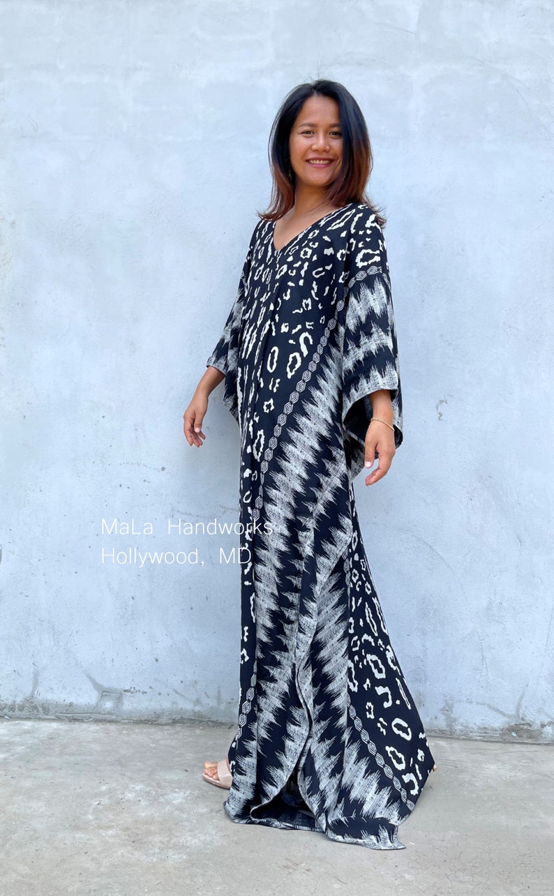 May include: A black and white maxi dress with a geometric pattern. The dress has a V-neckline and 3/4 sleeves. The dress is flowing and has a relaxed fit. The dress is made of a soft, comfortable fabric.  "MaLa Handworks Hollywood, MD"