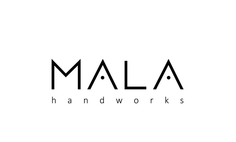 May include: Black and white logo for a business called "MALA handworks". The logo features a stylized "M" and two stylized "A"s, each with a small dot in the center.