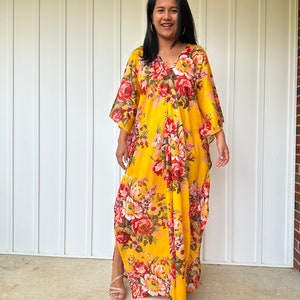 May include: A yellow maxi dress with a floral print. The dress has a V-neckline and 3/4 sleeves. The dress is flowy and has a relaxed fit.