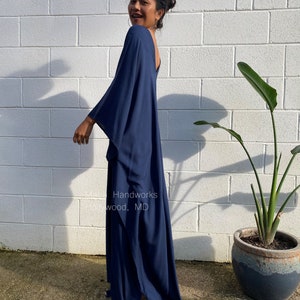 May include: A navy blue maxi dress with a loose, flowing fit and a deep V-neckline. The dress is made of a soft, comfortable fabric and has a relaxed, casual style. Handworks wood, MD.