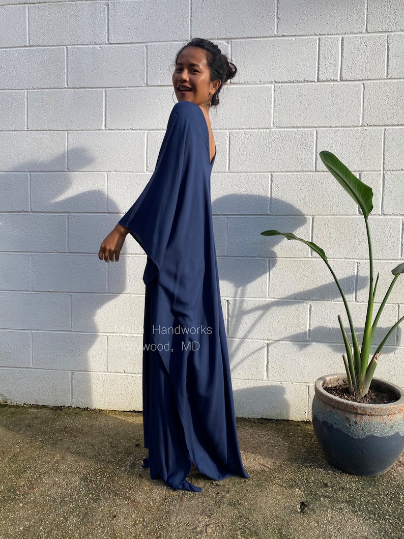 May include: A navy blue maxi dress with a loose, flowing fit and a deep V-neckline. The dress is made of a soft, comfortable fabric and has a relaxed, casual style. Handworks wood, MD.