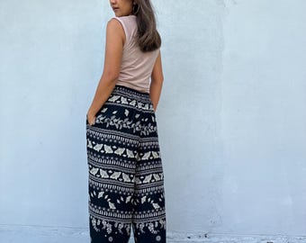 May include: Black and white patterned pants with a wide leg silhouette. The pants have a floral and geometric design.