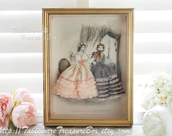 May include: A framed vintage print of two women in Victorian era dresses. The women are standing in a room with a window and a curtain. The print is in black and white and has a gold frame.