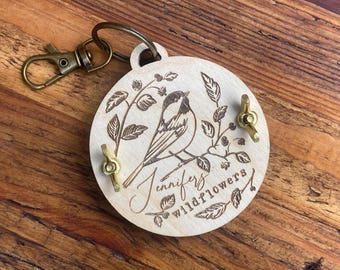 Llavero prensa de flores personalizado y de tamaño bolsillo con diseño floral grabado de pájaros.