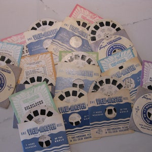 May include: A collection of vintage View-Master reels featuring various themes, including "7 More Wonders of the World", "Fairy Tale", "Goldilocks", and "Cinderella". The reels are made of cardboard and have a colourful design with the View-Master logo.