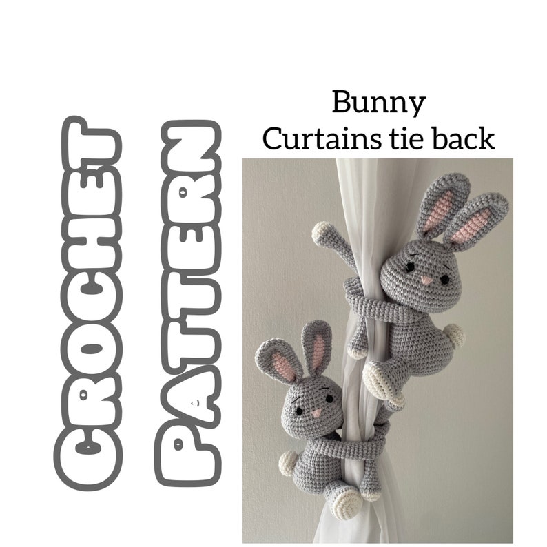 Puede incluir: Dos lazos para cortinas de conejito de crochet gris. Los conejos est&aacute;n agarrados a una cortina blanca con sus brazos y piernas. El texto "Bunny Curtains tie back" est&aacute; escrito encima de los conejos.