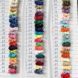 May include: A color chart of yarn samples, numbered 01 to 90. The yarn samples are arranged in rows of 20, with each row containing a different color. The colors include white, beige, light green, blue, pink, orange, red, yellow, and brown.