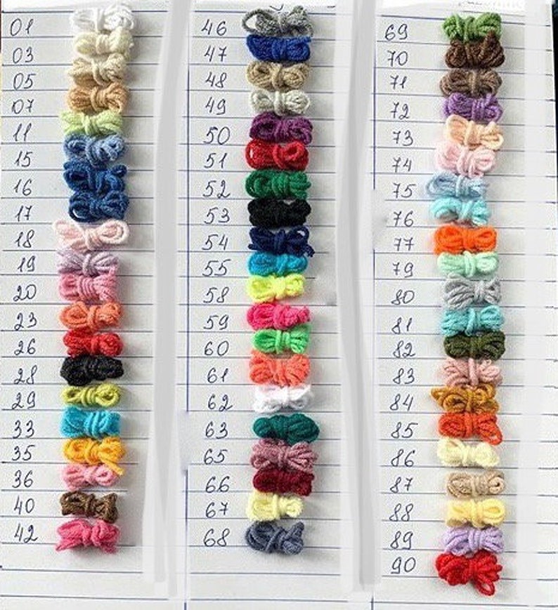 May include: A color chart of yarn samples, numbered 01 to 90. The yarn samples are arranged in rows of 20, with each row containing a different color. The colors include white, beige, light green, blue, pink, orange, red, yellow, and brown.