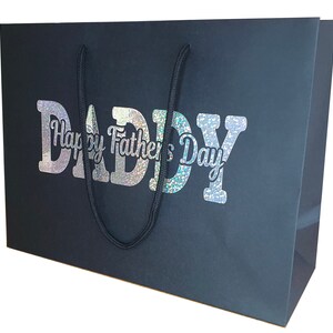 May include: Black gift bag with a holographic silver design that says "Happy Father's Day Daddy".