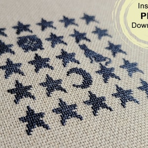 May include: A black and white cross stitch pattern featuring a crescent moon and stars on a beige linen fabric. The pattern is titled "Instant PDF Download!"