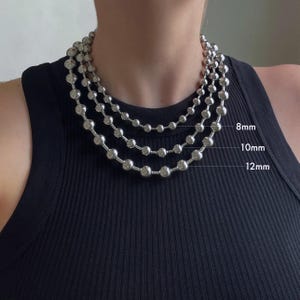 Peut inclure: Trois colliers en cha&icirc;ne argent avec des perles de diff&eacute;rentes tailles. Les perles mesurent 8 mm, 10 mm et 12 mm de diam&egrave;tre.