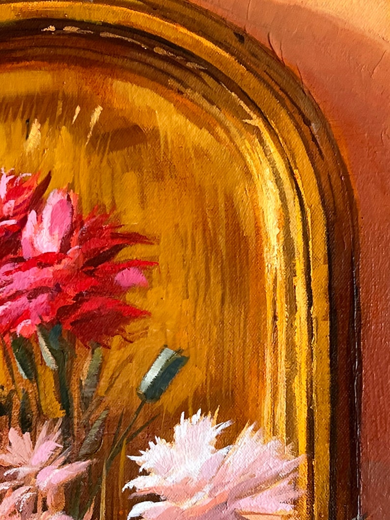 May include: A close-up of a painting of pink and red flowers in a gold frame. The flowers are painted in a realistic style and the frame is ornate.