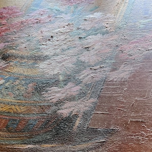 May include: A close-up of a painting depicting a vase with pink flowers. The vase is decorated with a geometric pattern in shades of blue, yellow, and brown. The background is a muted brown.