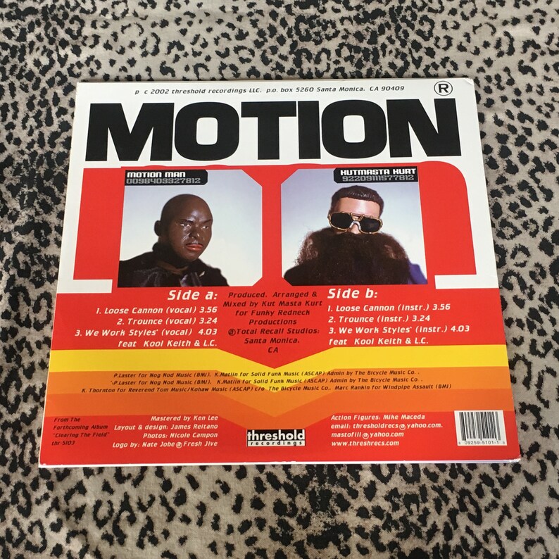 May include: A black and white album cover with the title "MOTION" in bold white letters. The cover features two men, one with a black beard and sunglasses, and the other with a shaved head. The album is by Motion Man and Hutmasta Hurt. The track list is included on the back of the album cover.