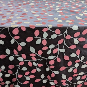 May include: Black fabric with a repeating pattern of pink and white leaves and branches.