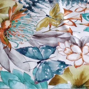 May include: A floral fabric with a watercolour design. It features teal, yellow, and orange flowers, butterflies, and fern-like leaves. The pattern is set against a white background, creating a vibrant and naturalistic aesthetic.