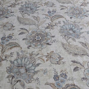 Tovaglia rettangolare di lusso in cotone biologico con motivo floreale, confezionata in un sacchetto regalo assortito.