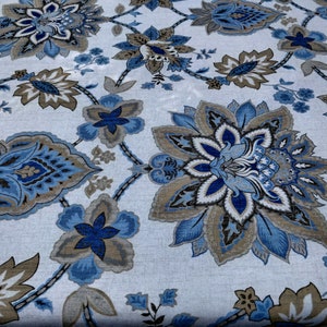 May include: A close-up of a fabric with a repeating floral pattern. The design features large, stylized flowers in shades of blue, brown, and grey against a light background. The floral elements are connected by a network of curved lines.