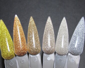 May include: Seven small bottles of glitter nail polish in various shades of gold and silver. The bottles are arranged in a row from left to right, with the gold shades on the left and the silver shades on the right.