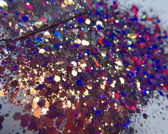 May include: A collection of loose craft glitter featuring a mix of hexagonal and fine particles in shades of deep purple, metallic copper, royal blue, and bright magenta, creating a highly reflective and multi-dimensional surface texture.